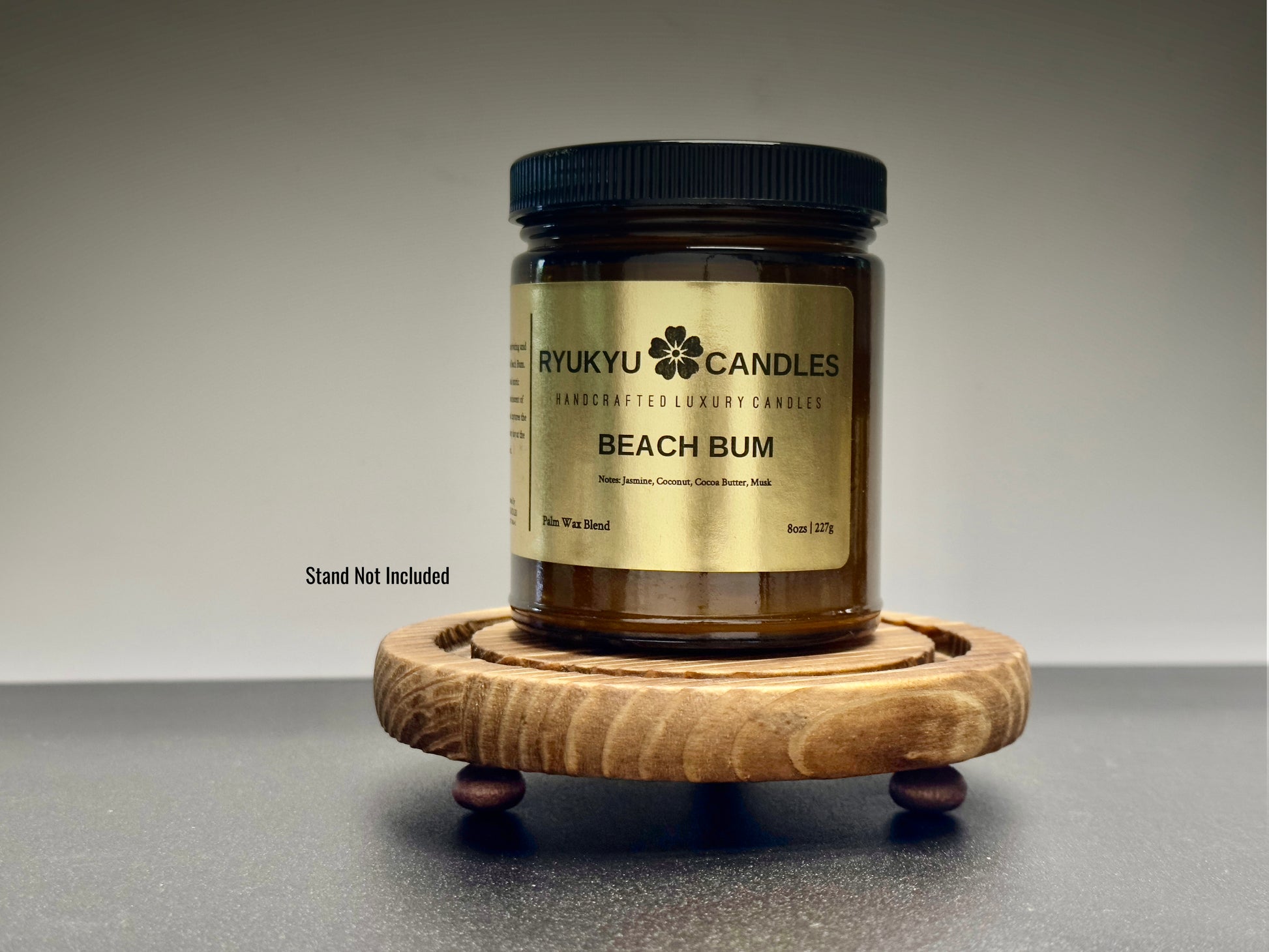 Jar of Ryukyu Candles Beach Bum candle on a wooden coaster with a gray background